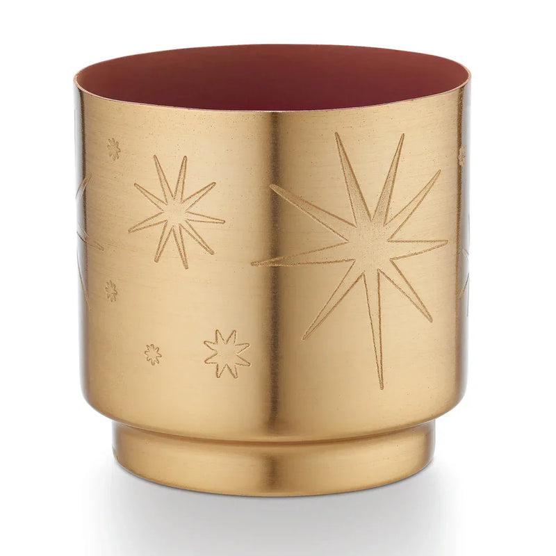 Gold-colored cylindrical ILLUME Tiny Tinsel Stars Candle with embossed star patterns