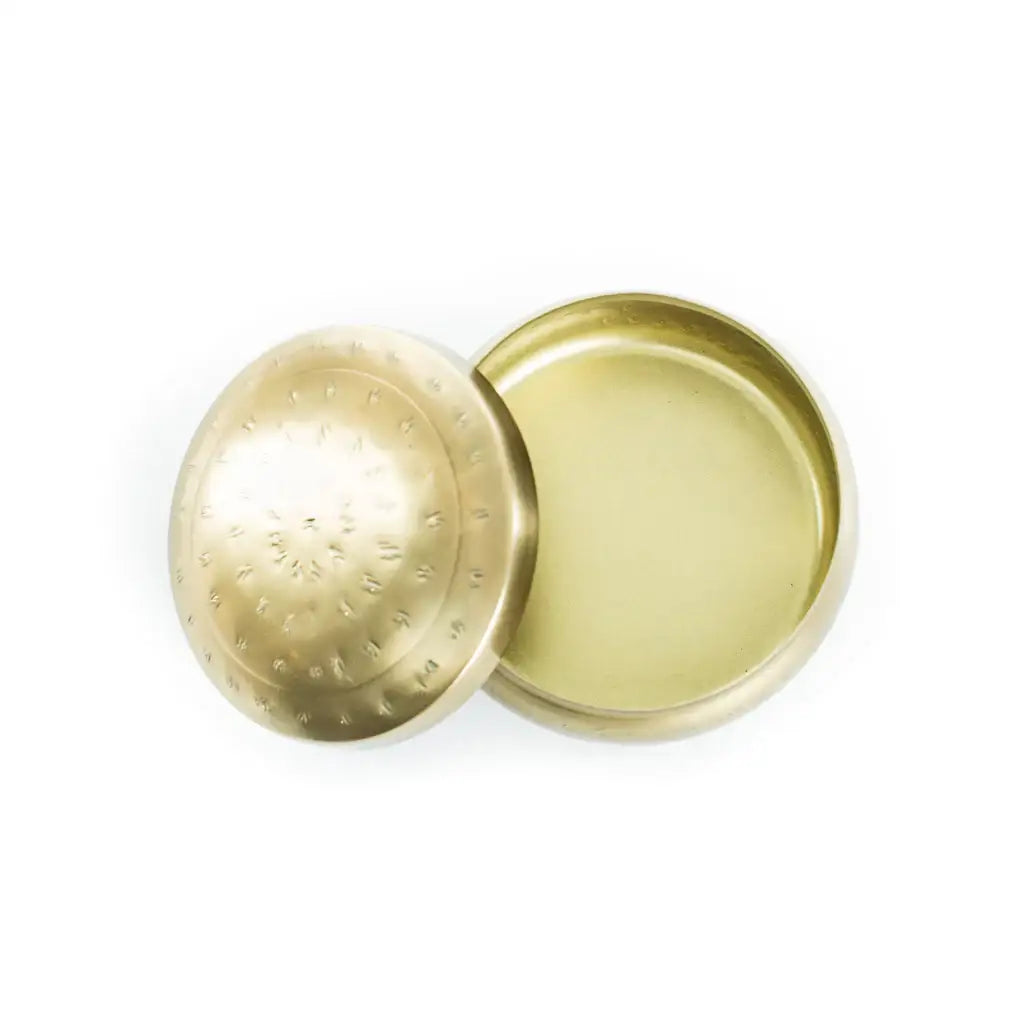 Gold metal jar lid of ROUND HAMMERED CONTAINER showcasing a brass finish and removed cap