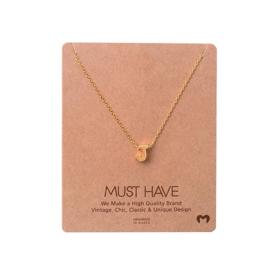 Gold heart necklace displayed on card in INITIAL J GOLD NECKLACE by Daisy Lane