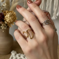 Gold wavy free size ring with heart-shaped polished finish
