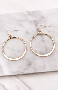 Gold hoop style earrings elegantly displayed in a luxurious presentation