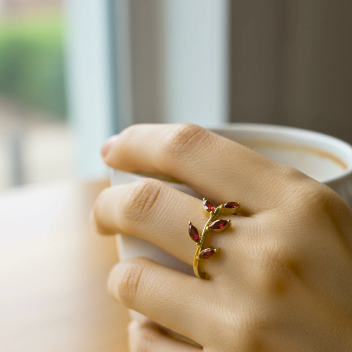 Gold emerald leaf vine ring with red gemstones and delicate design