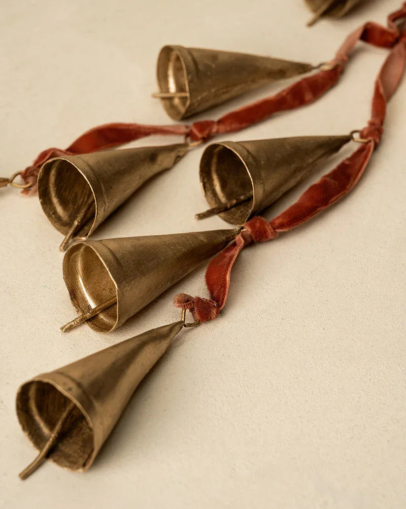 Gold metallic cone-shaped tassel garland with red velvet ribbon accents for door hanger decor