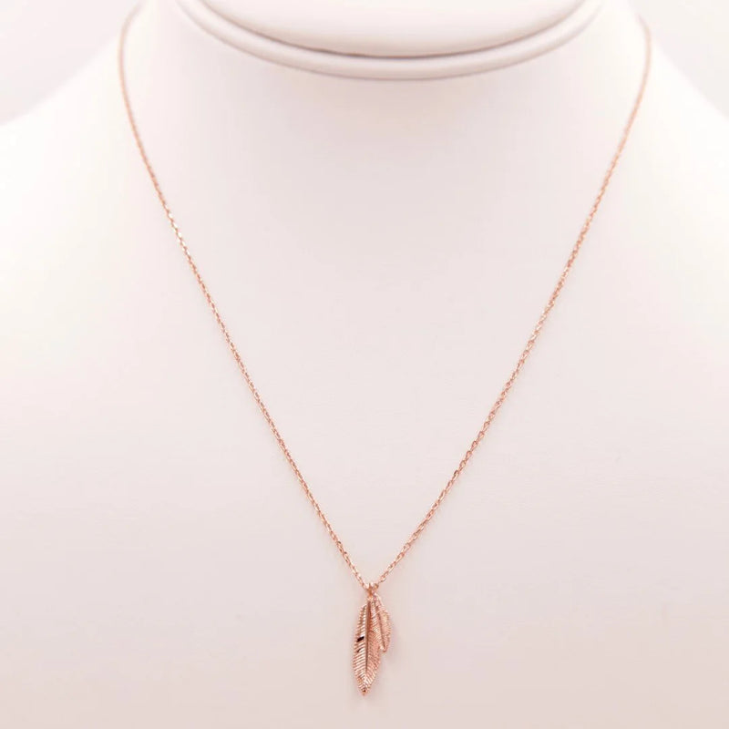 Gold feather necklace with a delicate rose gold charm for bohemian girls