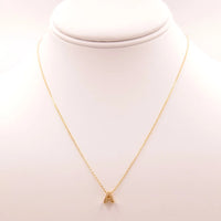 Gold necklace with a triangle pendant from Daisy Lane’s dainty initial collection