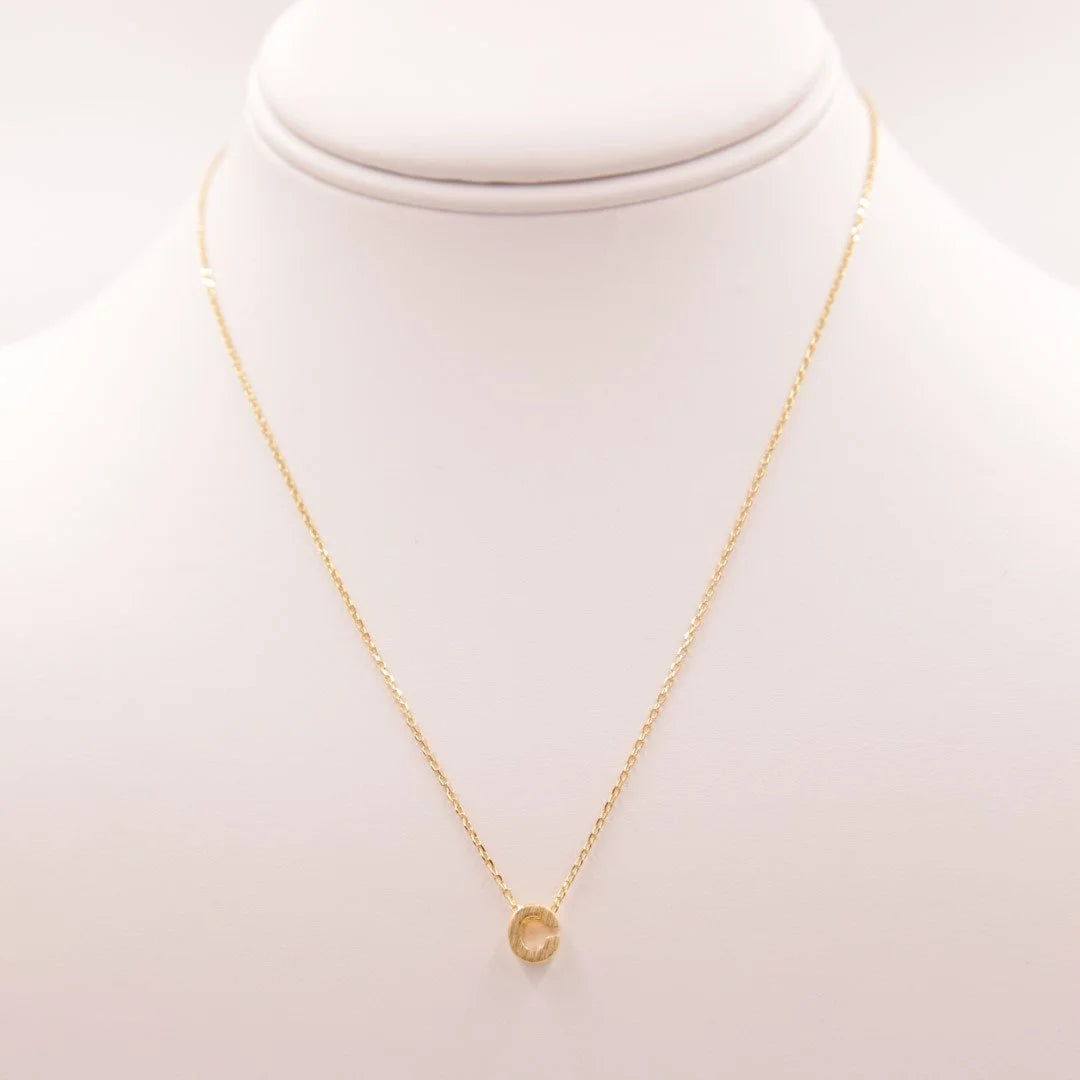 Dainty Initial C Gold Necklace from Daisy Lane, featuring a gold disc pendant