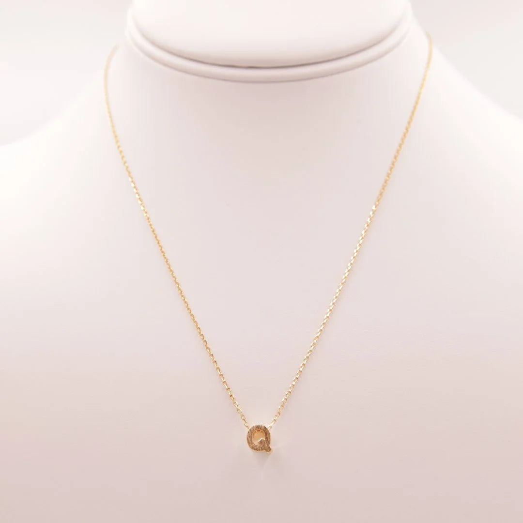 Gold Initial Q Necklace featuring a small diamond, ideal among Dainty Initial Necklaces