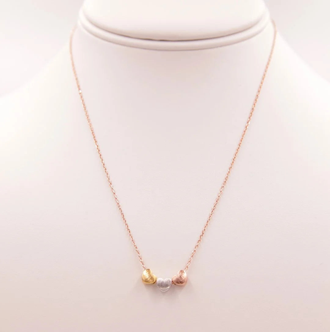 Tri Color Hearts Necklace featuring a gold and silver design with a pearl accent