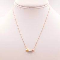 Tri Color Hearts Necklace featuring a gold and silver design with a pearl accent