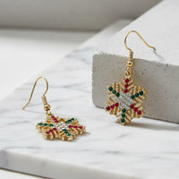 Festive rhinestone snowflake earrings with gold, red, and green gems