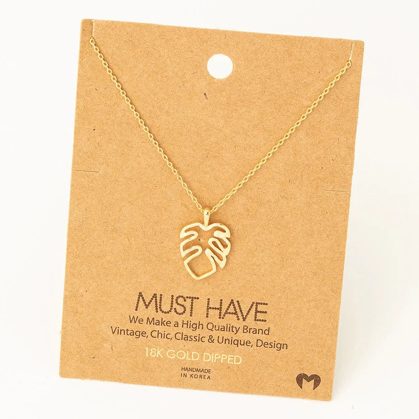 Gold-toned Monstera cutout pendant necklace on a delicate chain for elegant style