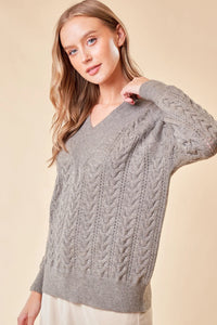 Gray cable-knit v-neck sweater featuring long sleeves from women’s boho chic clothing