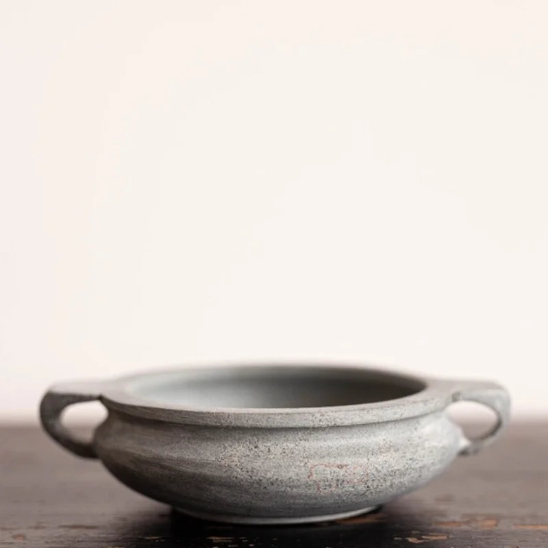Gray blue slate soapstone bowl with textured ceramic surface and handles