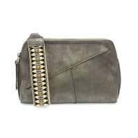 Gray leather handbag featuring a studded strap and woven wristlet strap design