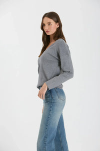 Gray long-sleeved seam knit sweater with drop shoulder, styled with blue jeans