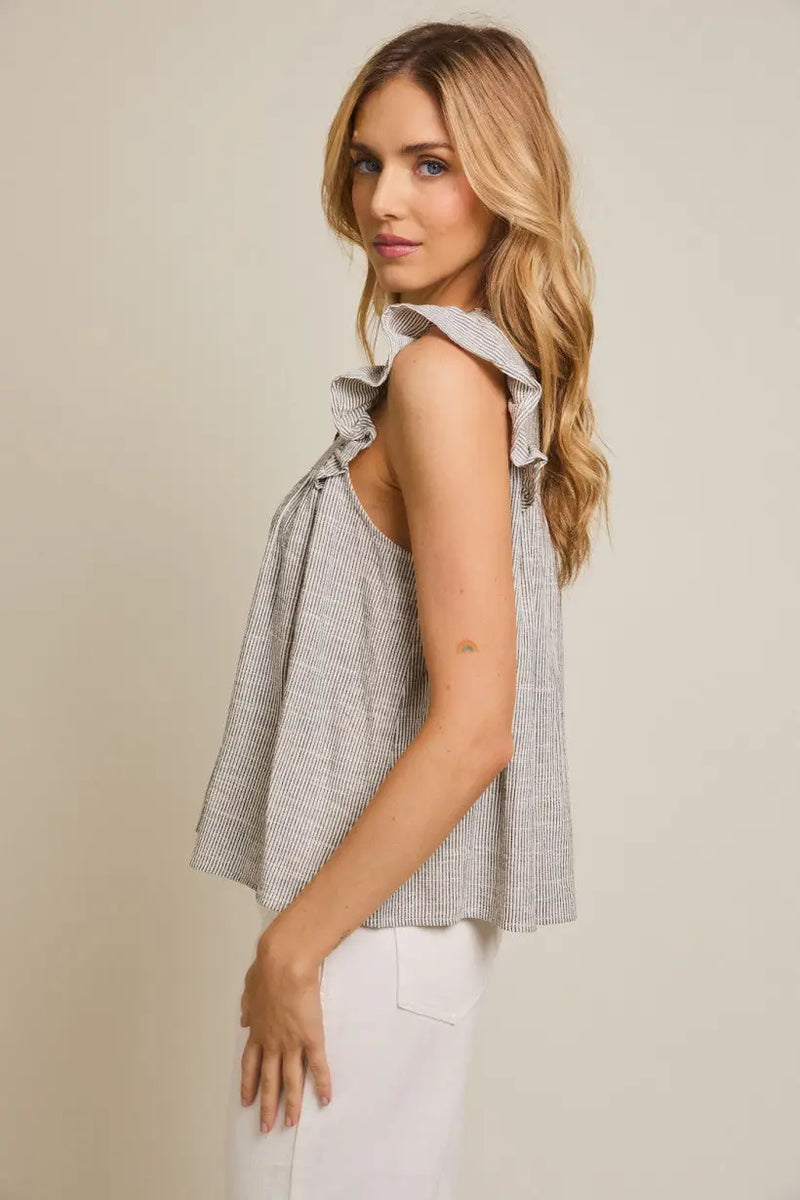 Gray ruffled sleeveless top with round neck and button details, featuring ruffle stripe accents