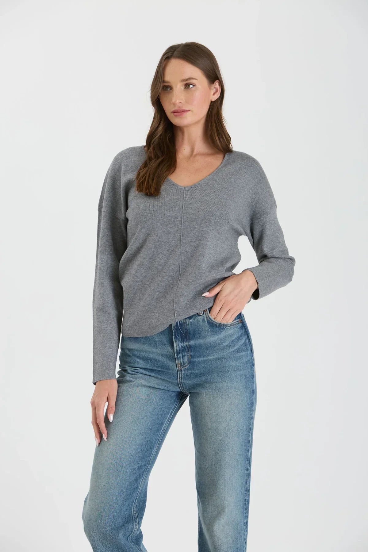 Gray seam knit sweater with drop shoulder and relaxed fit paired with light wash jeans