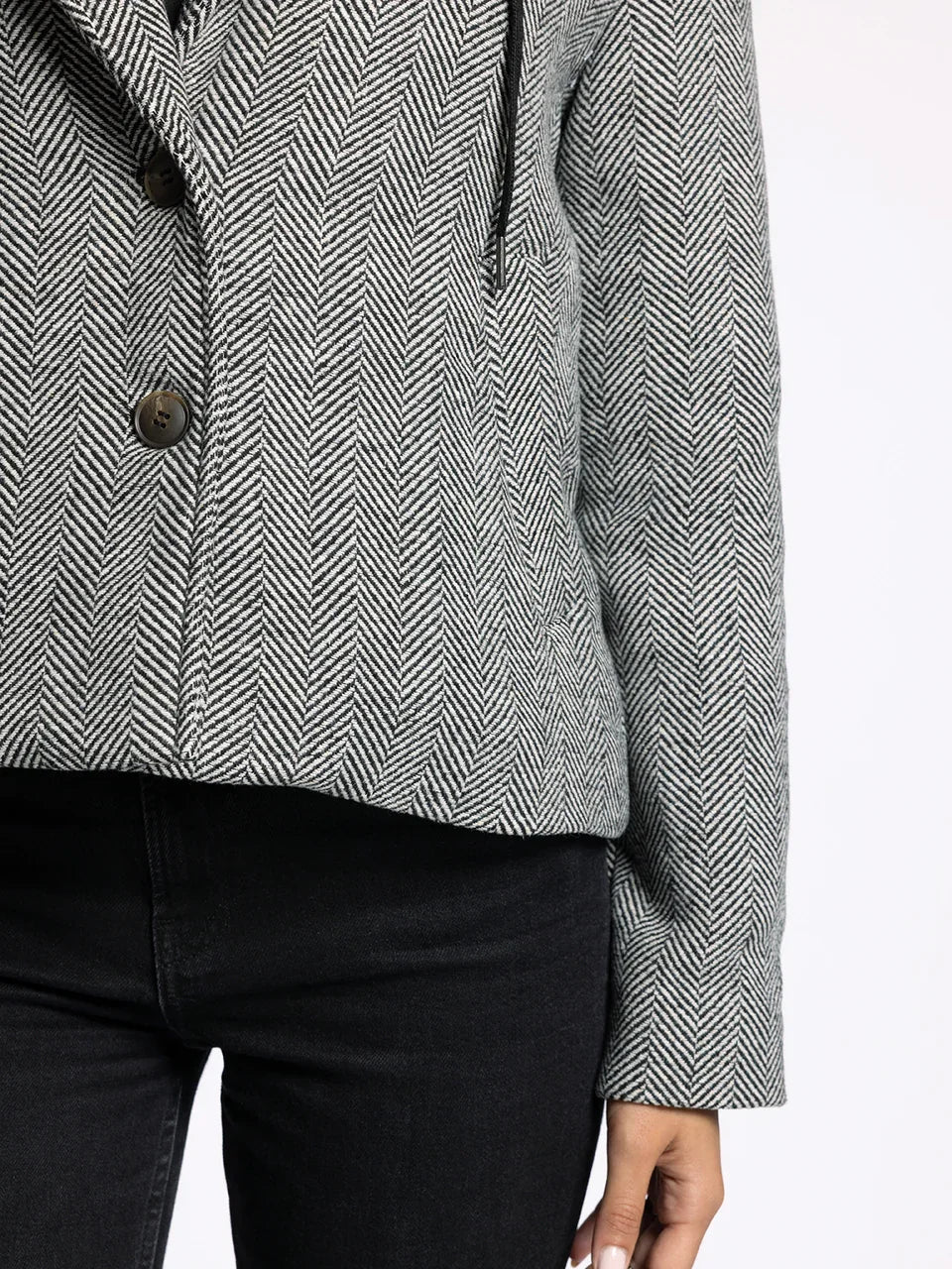 Gray and white herringbone tweed Alejandra Coat with front buttons over black pants