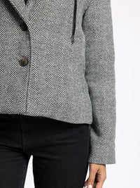 Gray and white herringbone tweed Alejandra Coat with front buttons over black pants