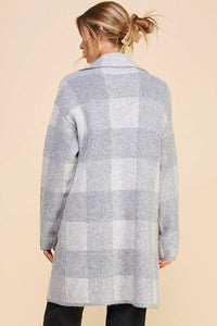 Gray and white plaid lapel cardigan worn by a person with blonde hair in a bun