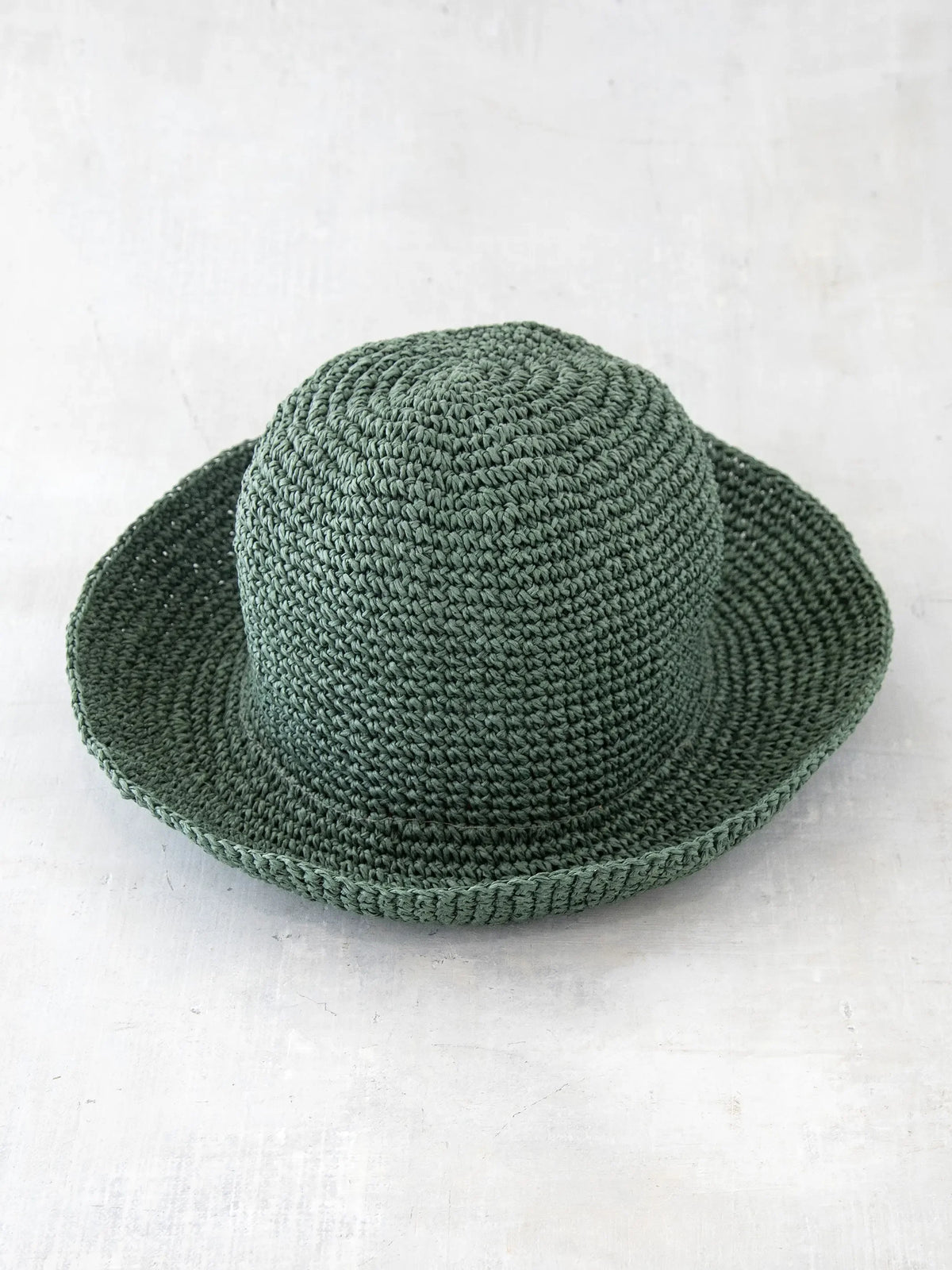 Green crocheted Kiara Bucket Hat with wide brim and rounded crown made of natural raffia