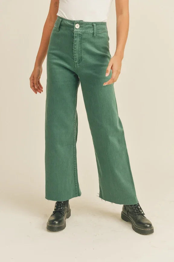 Green straight wide leg denim pants paired with stylish black boots