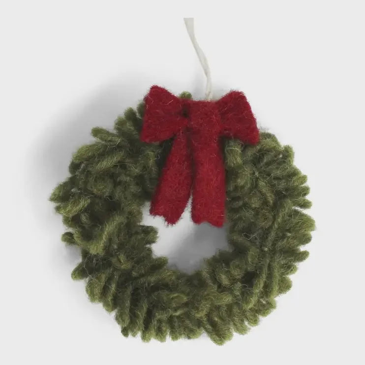 Handmade mini wreath ornament with green design, red bow, and white snowflake