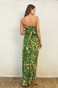 Green and yellow tropical leaf print boho maxi dress worn by woman from behind