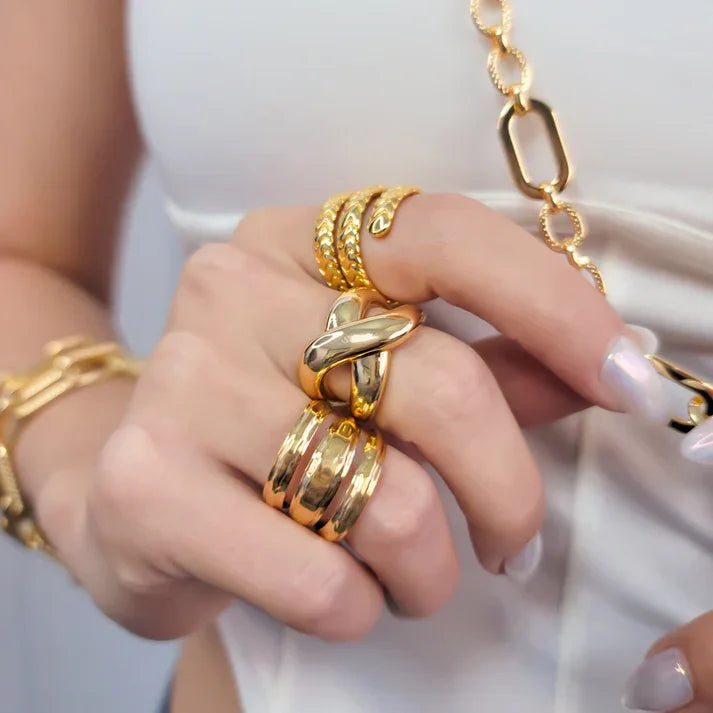 Hand wearing multiple gold rings and bracelet showcasing the cross ring adjustable gold ring