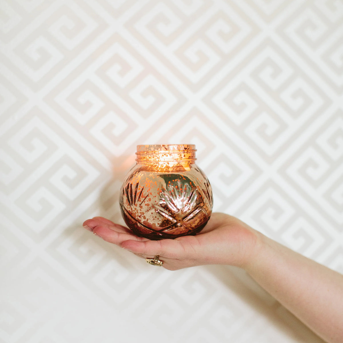 Hand holding a Soy-Blend Sweet Grace Candle, a best-selling fragrance candle