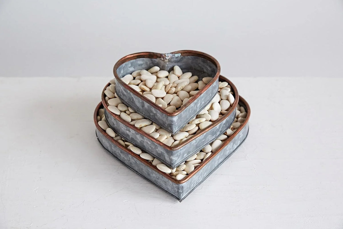 Heart shaped galvanized metal trays filled with white pebbles for decorative display