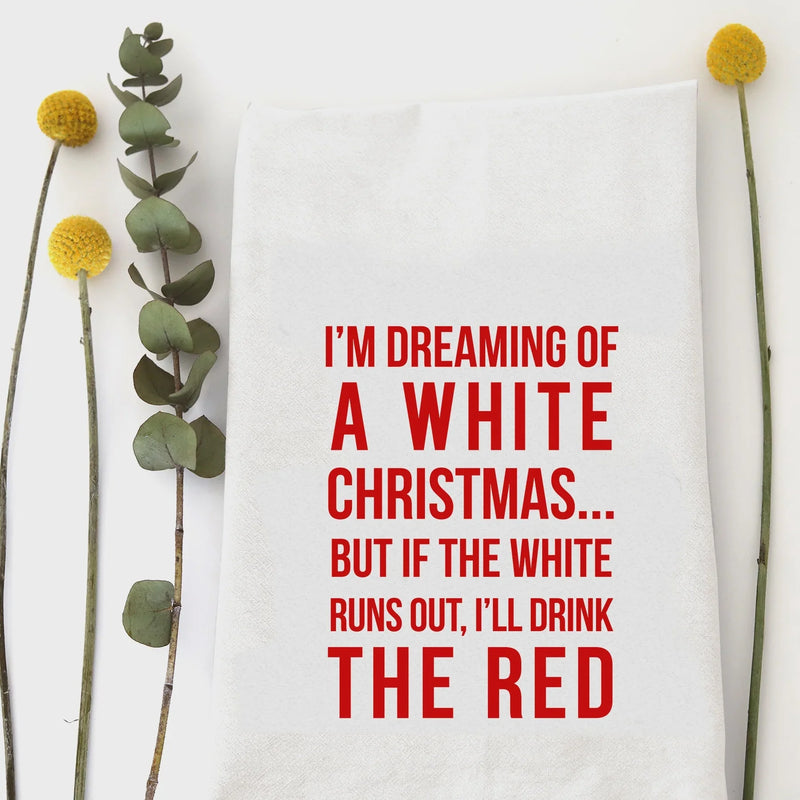 Humorous tea towel featuring dreaming of a white Christmas and red wine with plants