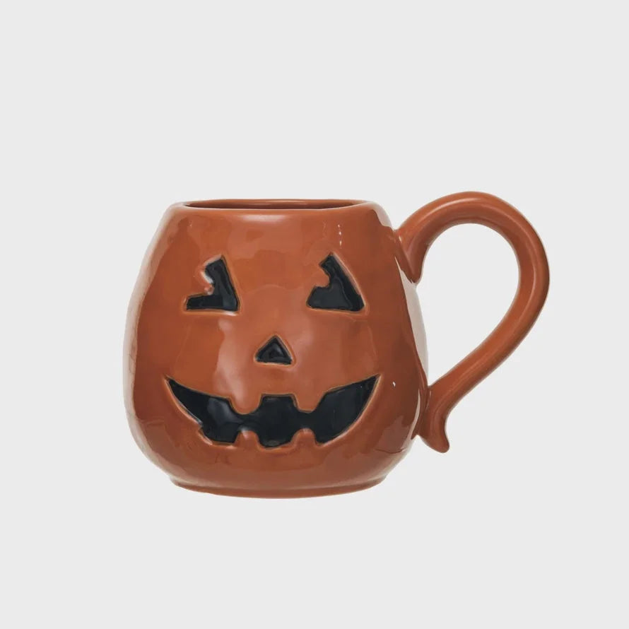 Jack-o-lantern shaped mug with carved face design, perfect for a boho chic Halloween