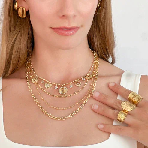 Layered water resistant gold necklaces with charms and rings showcasing gold adjustable oval design