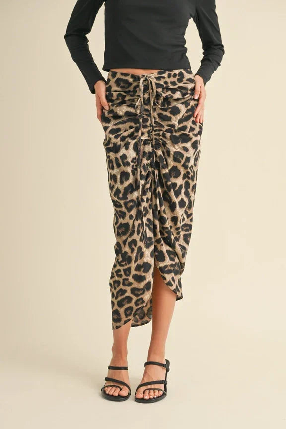 Leopard print midi skirt featuring ruching detail and asymmetrical hem