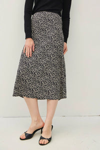 Leopard print midi skirt with elastic waistband styled with a black top and sandals