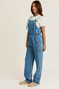 Light blue bow ties front denim overalls with white t-shirt and beige shoes in women’s boho chic clothing