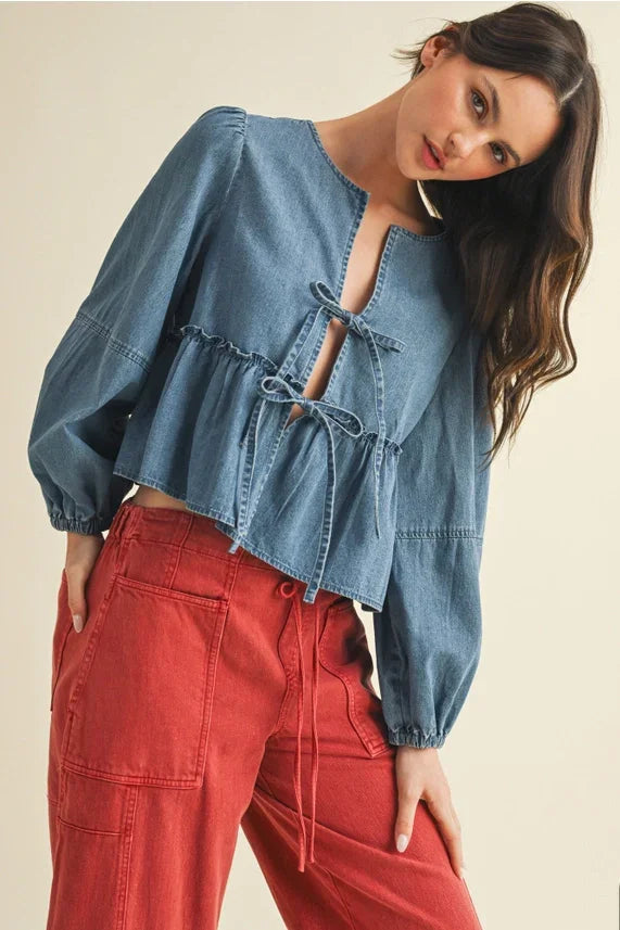 Light blue denim peplum top with ruffle hem and tie closure for stylish fashion