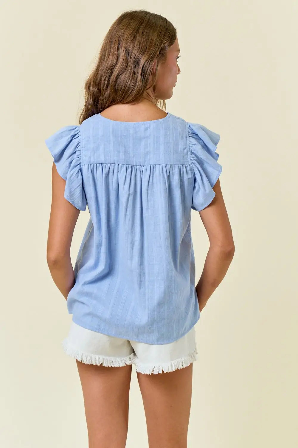 Light blue ruffled-sleeve blouse from Shop Daisy, perfect for women’s boho chic clothing