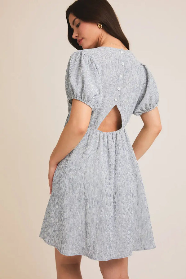 Light blue textured puff sleeve mini dress with back cutout, ideal for women’s boho chic clothing from Shop Daisy