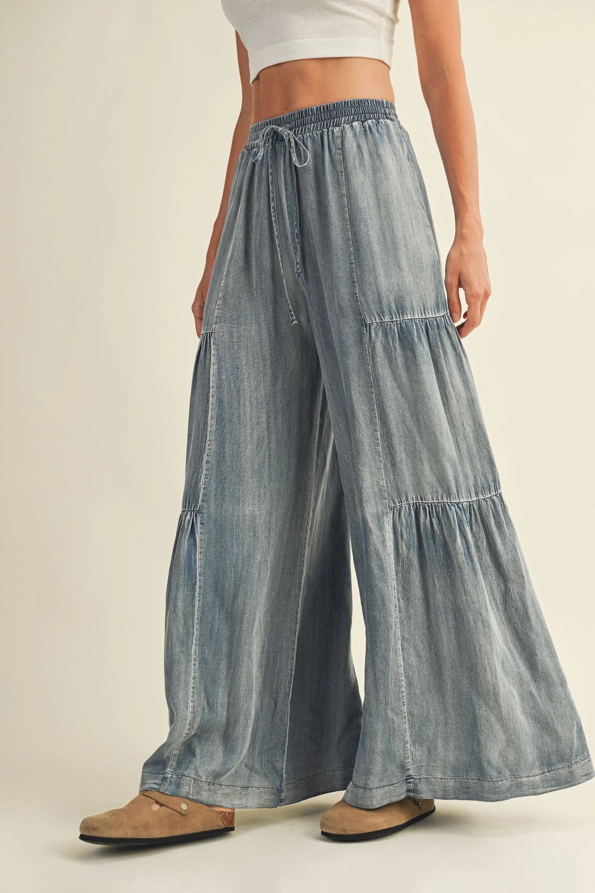 Light blue washed denim wide pants with tiered design and drawstring waistband