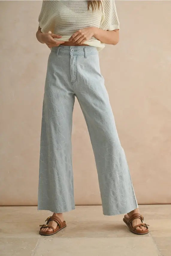 Light blue wide-leg denim pants with floral stitch pattern, ideal for women’s boho chic clothing