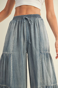 Light blue washed denim wide pants with elastic waist and drawstring for a comfortable fit