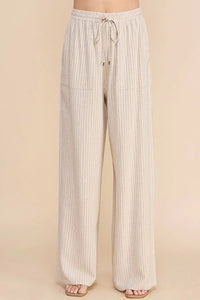 Light-colored striped linen smock waist pants with textured vertical pattern