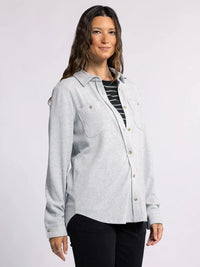 Light gray plush collared button down top worn over a striped shirt