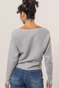 Light gray long sleeve sweater with ribbed texture paired with blue jeans