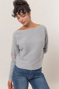 Light gray long sleeve sweater styled with blue jeans for a chic look