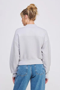 Light gray fine gauge dolman half zip sweater paired with blue jeans, featuring ribbing