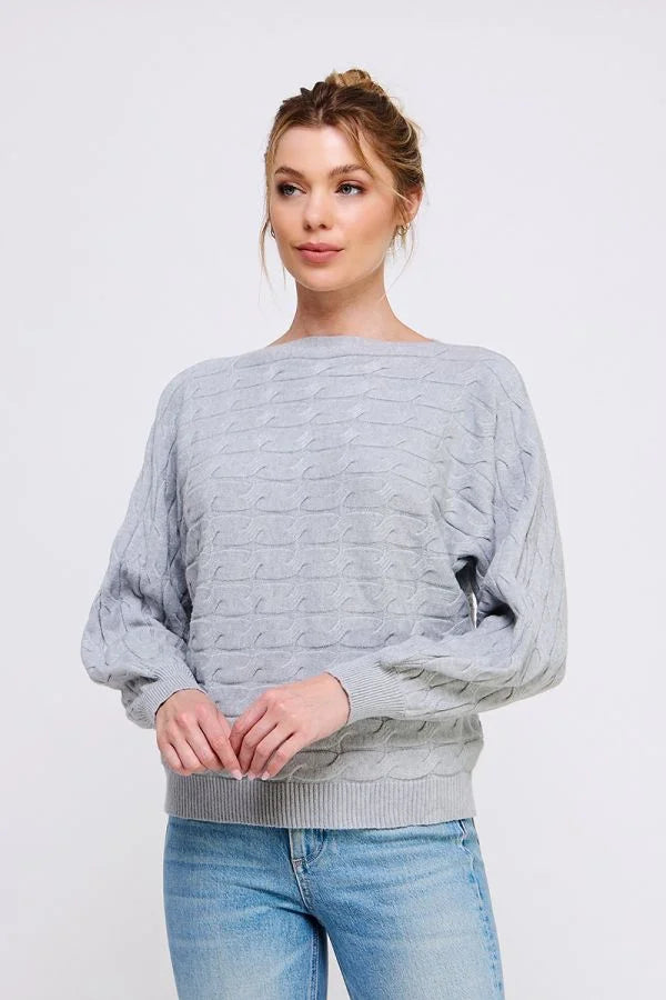 Light gray long sleeve cable knit sweater with puffy sleeves over blue jeans