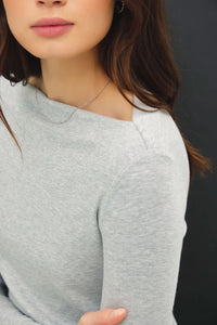 Light grey long sleeve knit top with basic boat neck and fitted silhouette